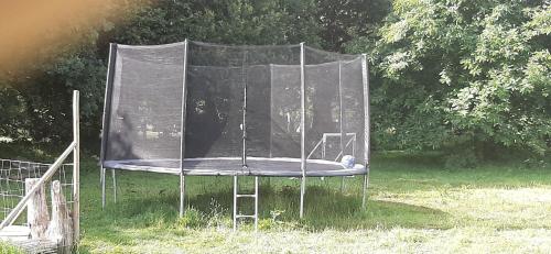 un trampoline métallique avec un couvercle sur l'herbe dans l'établissement Gîtes des Archanges, à Macey