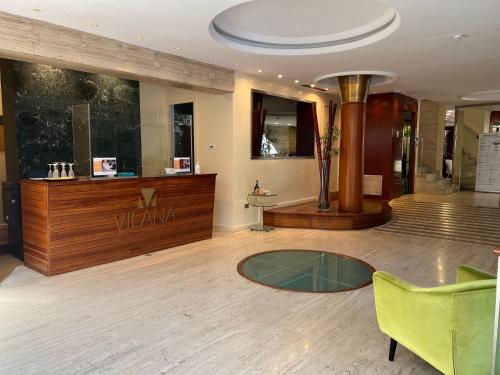 a lobby with a glass table and a green chair at Vilana Hotel Boutique in Barcelona