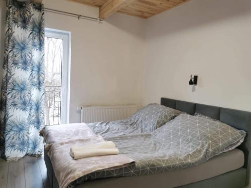uma cama num quarto branco com uma janela em AGRO-Jabłońscy em Miałkówek