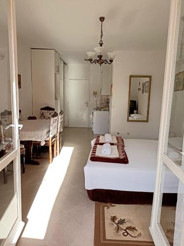 a bedroom with a bed and a dining room at Guesthouse Ljilja - apartment with balcony 2 in Meljine