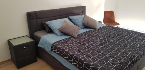 a bedroom with a bed with blue pillows at Gezellig appartement Beveren-Waas Donkvijver in Beveren