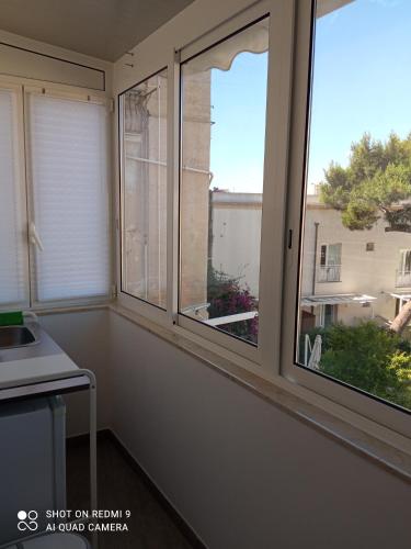 a kitchen with two windows and a sink at Catria in Favignana