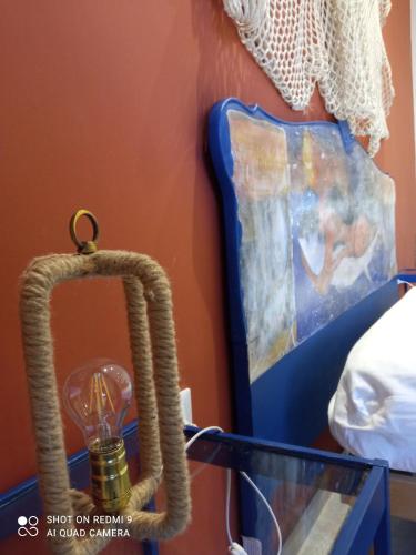 a lamp with a rope around it next to a painting at Catria in Favignana
