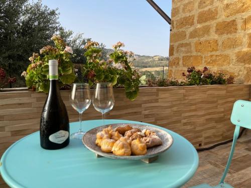 a table with a bottle of wine and a plate of food at Relais Dea Degli Ulivi in Agrigento
