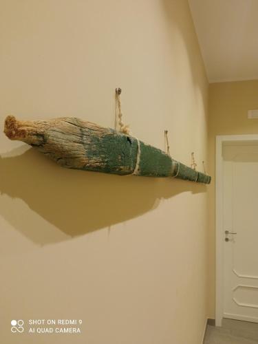 a log hanging on a wall in a room at Catria in Favignana