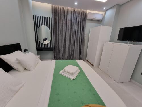 a bedroom with a white bed with a green rug at Vacation home near the sea in Durrës