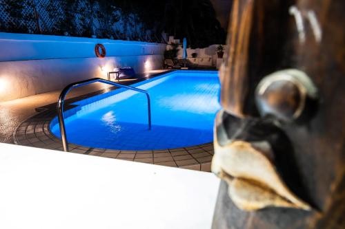 a swimming pool at night with a statue next to it at D View 4 You in Mellieħa
