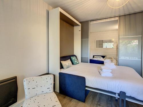 une petite chambre avec un lit et une chaise dans l'établissement Jardin Plein Sud, à Royan