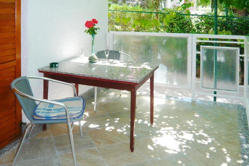 a table and two chairs and a vase with a flower on it at Happy Apartments, Biograd in Opatijski Torovi