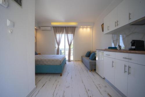 Habitación con cocina con cama y sofá en Golden View Studios, en Chrysi Ammoudia