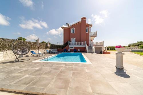 a villa with a swimming pool and a house at Five Stars Villa in Skala Kefalonias