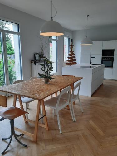 eine Küche und ein Esszimmer mit einem Tisch und Stühlen in der Unterkunft Les Tilleuls - Villa année 30 in Sancergues