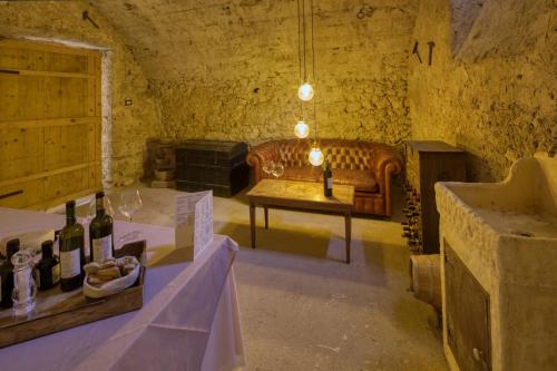 a room with a couch and a table with wine bottles at Borgo Incantato Spoleto in Pompagnano