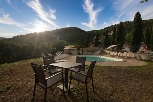 a table and chairs next to a swimming pool at Borgo Incantato Spoleto in Pompagnano