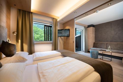 a bedroom with a large bed and a couch at Hotel Alpina in Rauris