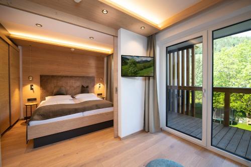 a bedroom with a bed and a balcony at Hotel Alpina in Rauris