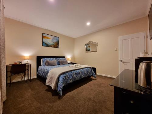 a bedroom with a bed with a blue bedspread at Melody in Gore