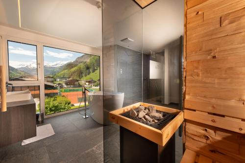 a bathroom with a tub with a view of a mountain at Hotel Alpina in Rauris