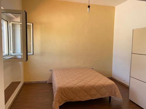 - une chambre avec un lit dans une pièce dotée d'une fenêtre dans l'établissement Villa Alma, à Collepasso