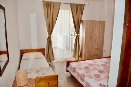 een slaapkamer met 2 bedden en een raam bij Apartments Petar Maksan in Pakoštane