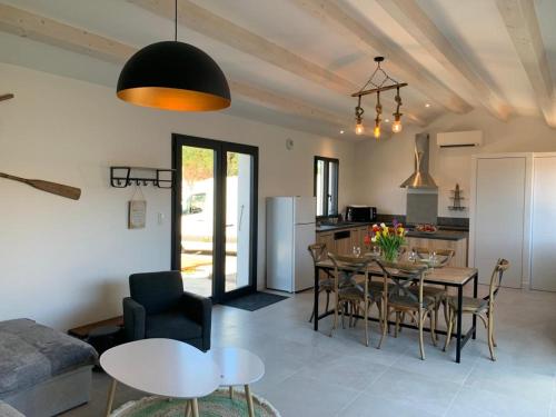 eine Küche und ein Wohnzimmer mit einem Tisch und Stühlen in der Unterkunft Le moulin des sables, maison rétaise. in La Flotte
