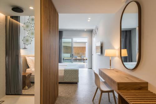 a hotel room with a desk and a mirror at Sensus Experience by Lavris in Gouves