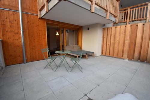un patio avec une table et des chaises dessus dans l'établissement VAUJANYLOCATIONS - La Cabane de Maurice, à Vaujany