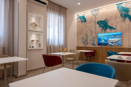 a restaurant with tables and chairs and a painting on the wall at Hotel Biagi & Residence in Lido di Camaiore