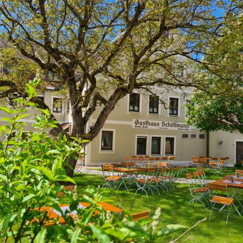 a building with tables and chairs and a tree at Gasthaus Schöllmann in Feuchtwangen