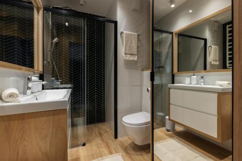 uma casa de banho com um WC, um lavatório e um chuveiro em Wine Apartment Gdynia em Gdynia