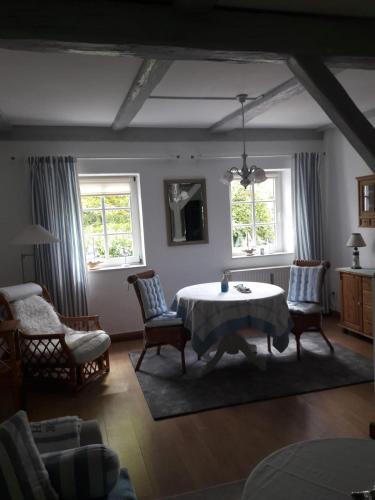 a living room with a table and chairs and two windows at Möwe in Steffenshagen