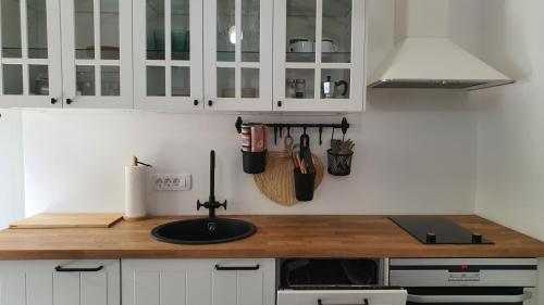 a kitchen with white cabinets and a wooden counter top at Apartment Ariela in Izola