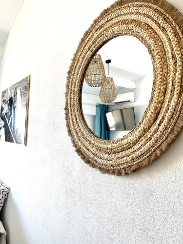 un miroir rond en rotin suspendu sur un mur dans l'établissement coup de cœur, à Grimaud