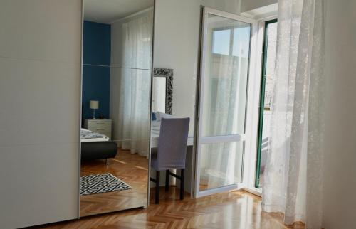 a mirror in a room with a chair next to a window at VIlla Ribar in Podgora