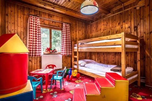 a bedroom with a bunk bed and a table and chairs at Chata Partizán in Liptovský Ján