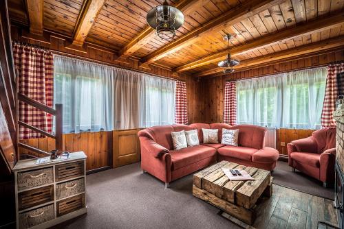 a living room with a couch and a tv at Chata Partizán in Liptovský Ján