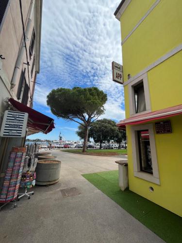 a yellow building with a tree in the background at Zimmer Umago in Umag