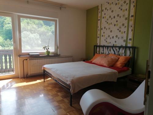 Schlafzimmer mit einem Bett und einem Fenster in der Unterkunft Beautiful house in idyllic location in Rogatec