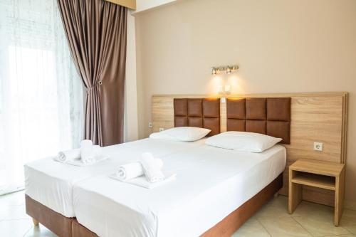a bedroom with a large bed with two white pillows at Sun Studios Pieria in Paralía Skotínis