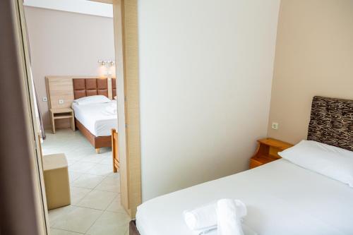 a small room with two beds and a mirror at Sun Studios Pieria in Paralía Skotínis