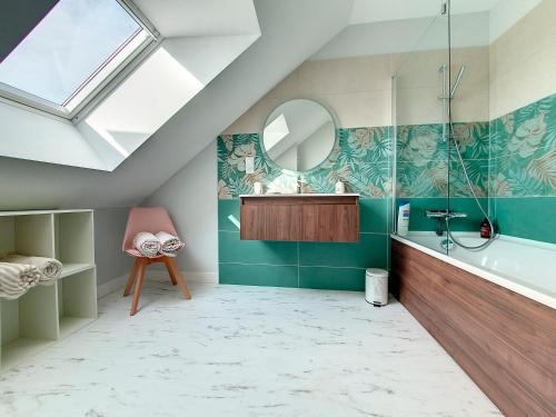 W łazience znajduje się umywalka, lustro i wanna. w obiekcie Au Mont Chez Vous #Jacuzzi et Vue Mont-St-Michel# w mieście Huisnes-sur-Mer