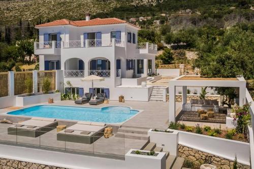 een villa met een zwembad en een huis bij Lourdas White Villa in Kefallonia