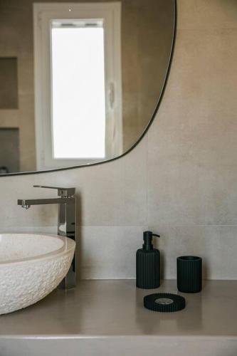 a bathroom with a sink and a mirror at Lourdas White Villa in Kefallonia