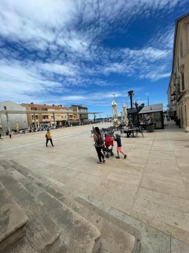 a group of people walking around in a plaza at Zimmer Umago in Umag