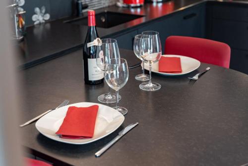 a table with plates and glasses and a bottle of wine at Le Domaine de Wisbeley in Halet