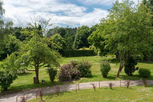 a garden with trees and bushes and a fence at Le Domaine de Wisbeley in Halet