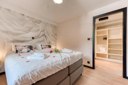 a bedroom with a large bed with white sheets at Le Domaine de Wisbeley in Halet