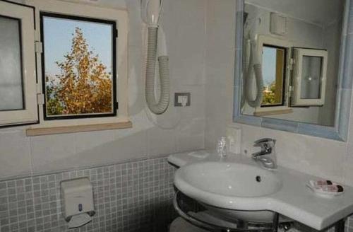 a bathroom with a sink and a mirror at Hotel Corallo in Francavilla al Mare