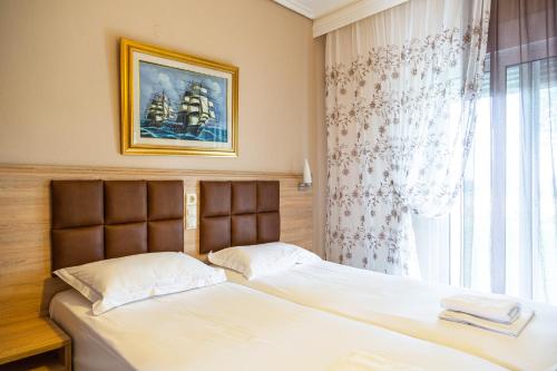 a bedroom with a bed and a window with a picture at Sun Studios Pieria in Paralía Skotínis