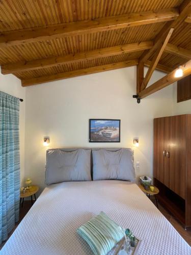 a bedroom with a bed with a wooden ceiling at Elenas Studios in Vourvourou